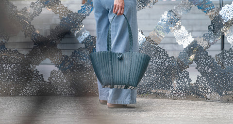 Ettie woven market tote bag filled with bread, pineapple and groceries on sunlit surface