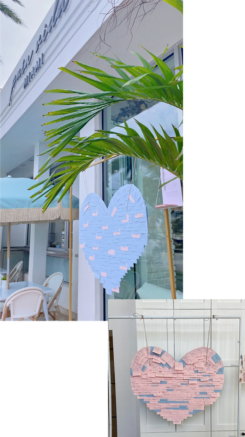 Installation of pastel blue hearts covered in handwritten notes inside Pura Vida Miami café