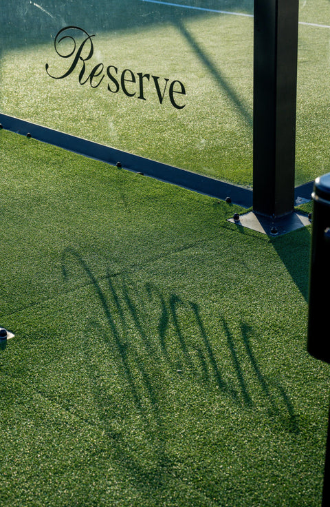 Lifestyle photo of Reserve padel court in Miami with logo reflected on green turf